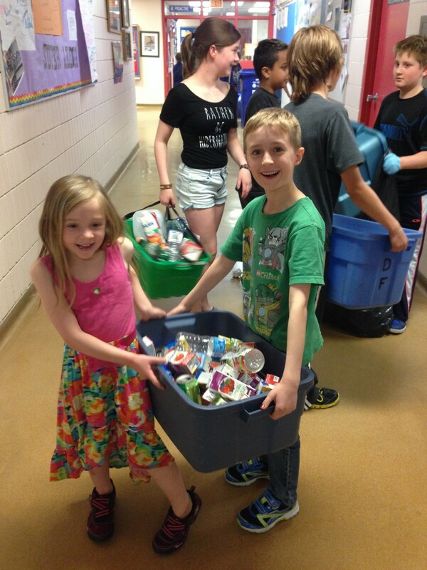 two kids holding a bin of recycle containers